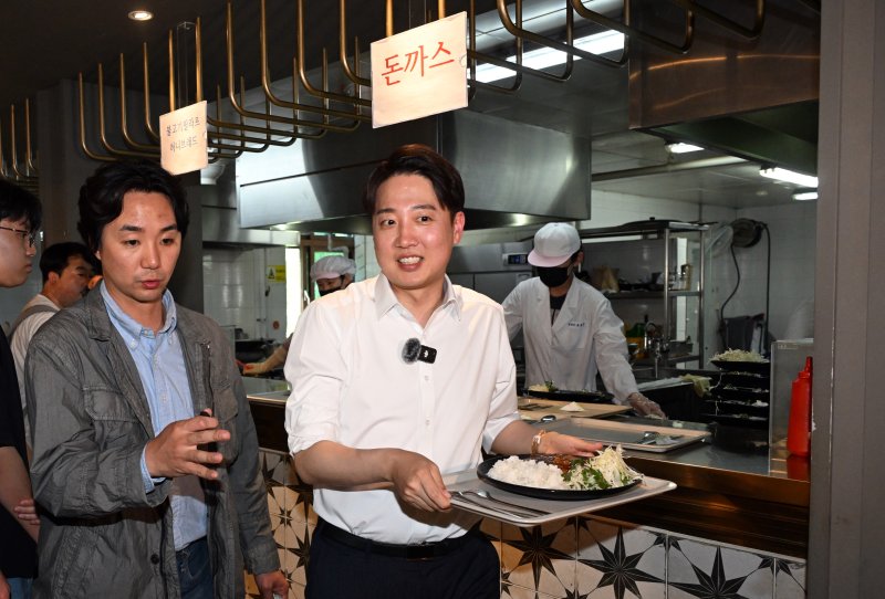 이준석 개혁신당 대선 후보가 지난 13일 대구 북구 경북대학교를 찾아 학생식당에서 주문한 돈가스를 받고 있다. 공동취재