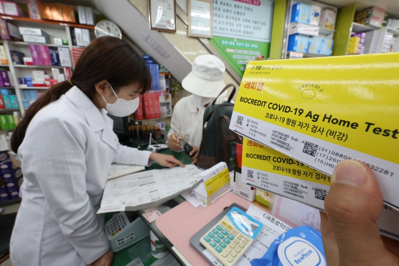 서울 종로구 새종로약국에서 약사가 코로나19 자가 키트를 구매하는 고객에게 사용법을 알려주고 있다. 뉴스1 제공