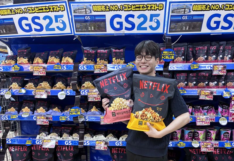  고객이 일본 돈키호테에 입점한 GS25의 넷플릭스 점보 팝콘을 들고 환하게 웃고 있다. <span id='_stock_code_007070' data-stockcode='007070'>GS리테일</span> 제공