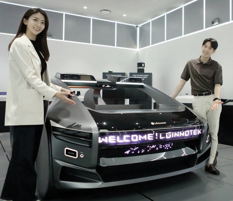 LG이노텍 직원들이 미래차 목업(Mock-up)에 장착된 차량 조명 모듈 ‘넥슬라이드’를 선보이고 있다. LG이노텍 제공