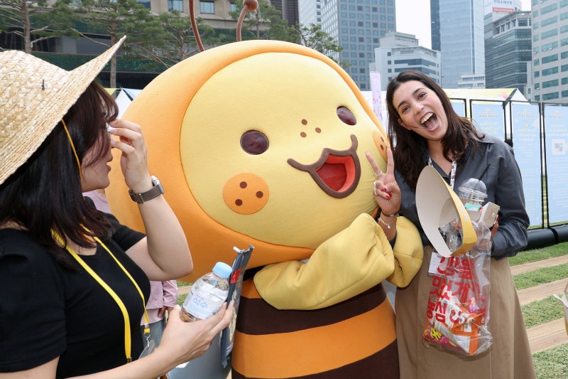 28일 서울 중구 서울광장에서 열린 2025 서울식품유통대전(K푸드쇼)을 찾은 여성 외국인이 K스낵 기업의 캐릭터와 환한 표정으로 포즈를 취하고 있다. 사진=서동일 기자
