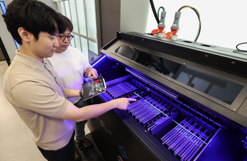 <span id='_stock_code_003550' data-stockcode='003550'>LG</span>유플러스 직원들이 데모룸에 설치된 액체냉각장치를 살펴보고 있는 모습. <span id='_stock_code_032640' data-stockcode='032640'>LG유플러스</span> 제공