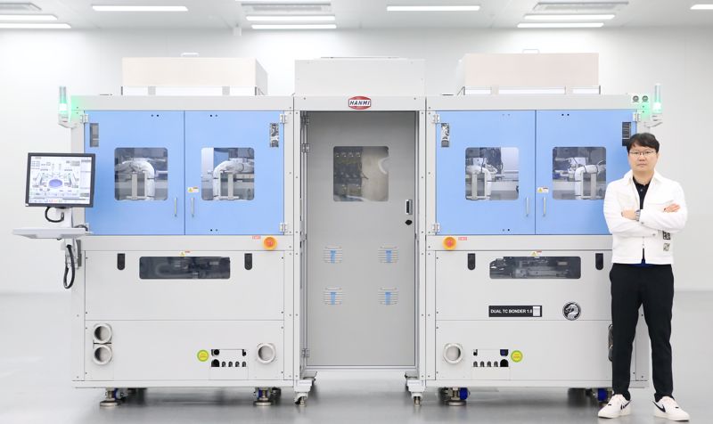 곽동신 <span id='_stock_code_042700' data-stockcode='042700'>한미반도체</span> 회장과 TC본더 장비. 한미반도체 제공