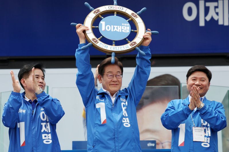 이재명 더불어민주당 대선후보가 31일 오후 경기 평택시 배다리생태공원에서 열린 유세에서 '진짜 대한민국' 이라고 적힌 조타기를 들어 보이고 있다. 사진=뉴시스