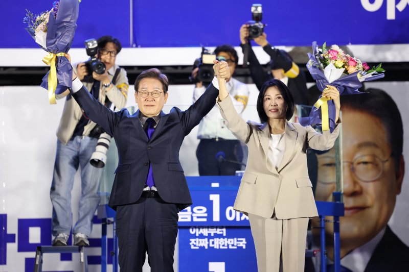 이재명 더불어민주당 대통령 후보와 부인 김혜경 여사가 4일 오전 당선이 확실시되자 서울 여의도 국회 앞을 찾아 꽃다발을 받아 들어보이고 있다. 사진=뉴스1