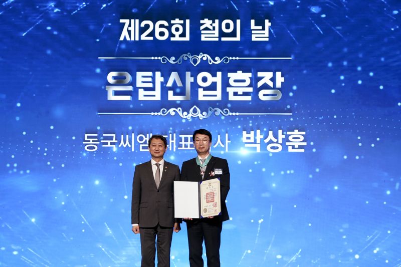 박상훈 <span id='_stock_code_460850' data-stockcode='460850'>동국씨엠</span> 대표이사 사장(오른쪽)이 9일 서울 삼성동 인터컨티넨탈호텔에서 열린 '제26회 철의 날' 기념행사에서 은탑산업훈장을 수상한 뒤 안덕근 산업부장관과 기념촬영을 하고 있다. <span id='_stock_code_460860' data-stockcode='460860'>동국제강</span> 제공