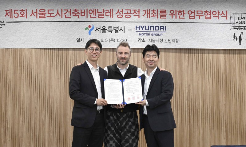 안중욱 서울시 미래공간담당관(왼쪽부터), 토마스 헤더윅 총감독, 홍래욱 <span id='_stock_code_005380' data-stockcode='005380'>현대차</span>그룹 글로벌디자인매니지먼트팀 상무가 지난 5일 서울시청에서 열린 업무협약식에서 기념 촬영을 하고 있다. 현대자동차그룹 제공