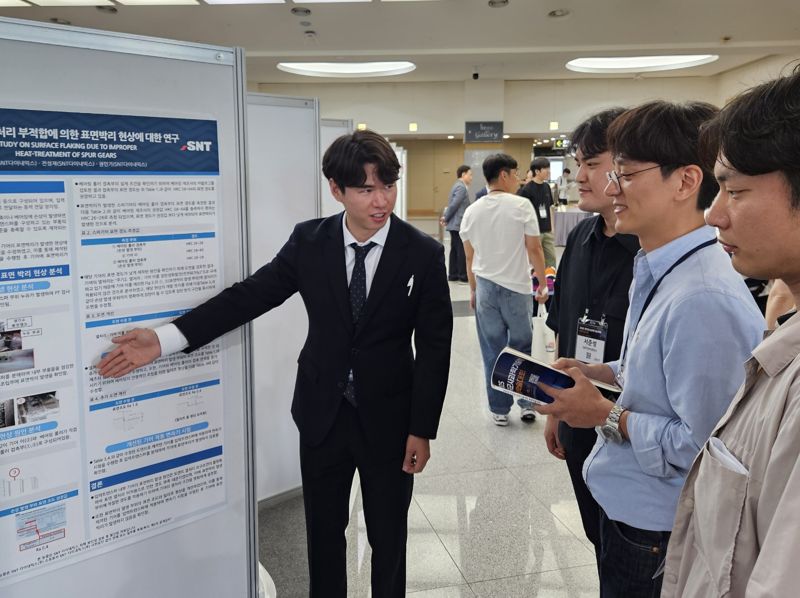 SNT다이내믹스 박성호 엔지니어(왼쪽)가 11일 한국군사과학기술학회 종합학술대회에서 연구논문 발표를 하고 있다. SNT다이내믹스 제공