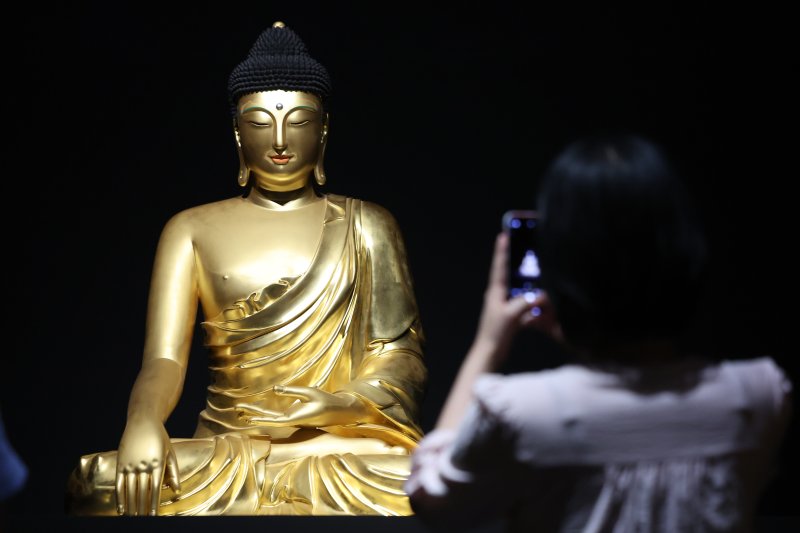 서울 용산구 국립중앙박물관에서 열린 '새 나라 새 미술:조선 전기 미술 대전' 특별전에서 관람객이 조계사 목조여래좌상을 살펴보고 있다. 뉴스1