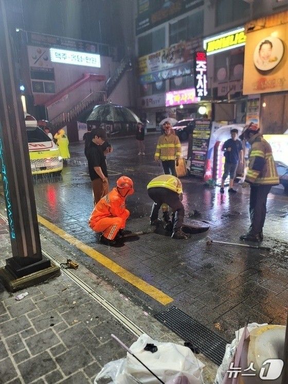 14일 오전 2시 33분쯤 부산 연제구 연산동에 닫혀있지 않던 맨홀 구멍에 대해 소방이 안전조치를 취하고 있다.&#x2F;사진&#x3D;부산소방재난본부 제공.