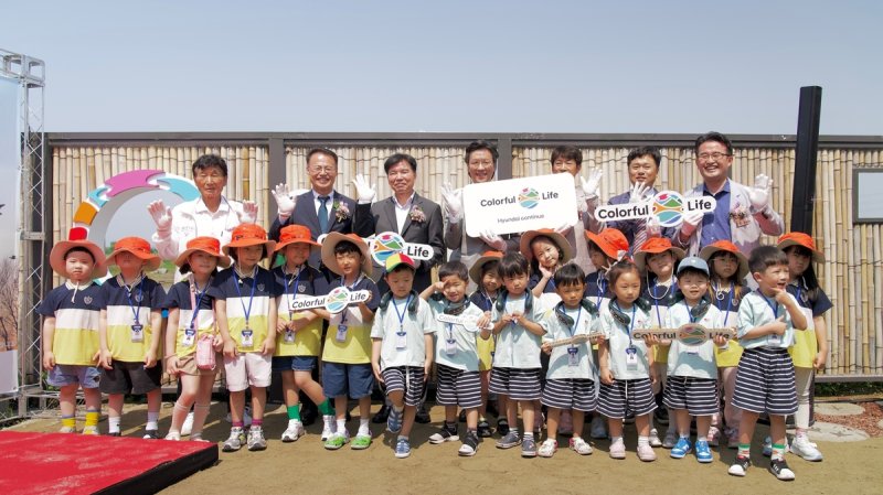 아산 군덕1리 박응진 이장(뒷줄 왼쪽부터), 한국환경보전원 신진수 원장, 아산시 조일교 부시장, <span id='_stock_code_005380' data-stockcode='005380'>현대차</span> GPO 김일범 부사장, 천안아산환경운동연합 차수철 의장, 현대차 정상익 안전기획사업부장, 충청남도의회 안장헌 의원이 지역 어린이들과 기념 사진을 촬영하는 모습. 현대자동차그룹 제공