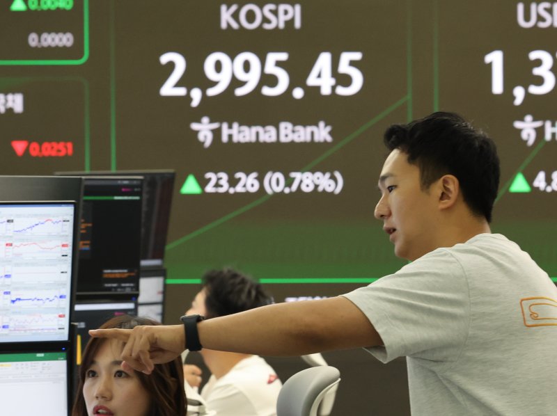 코스피가 상승 출발한 19일 서울 중구 하나은행 딜링룸에서 딜러들이 대화하고 있다. 연합뉴스 제공