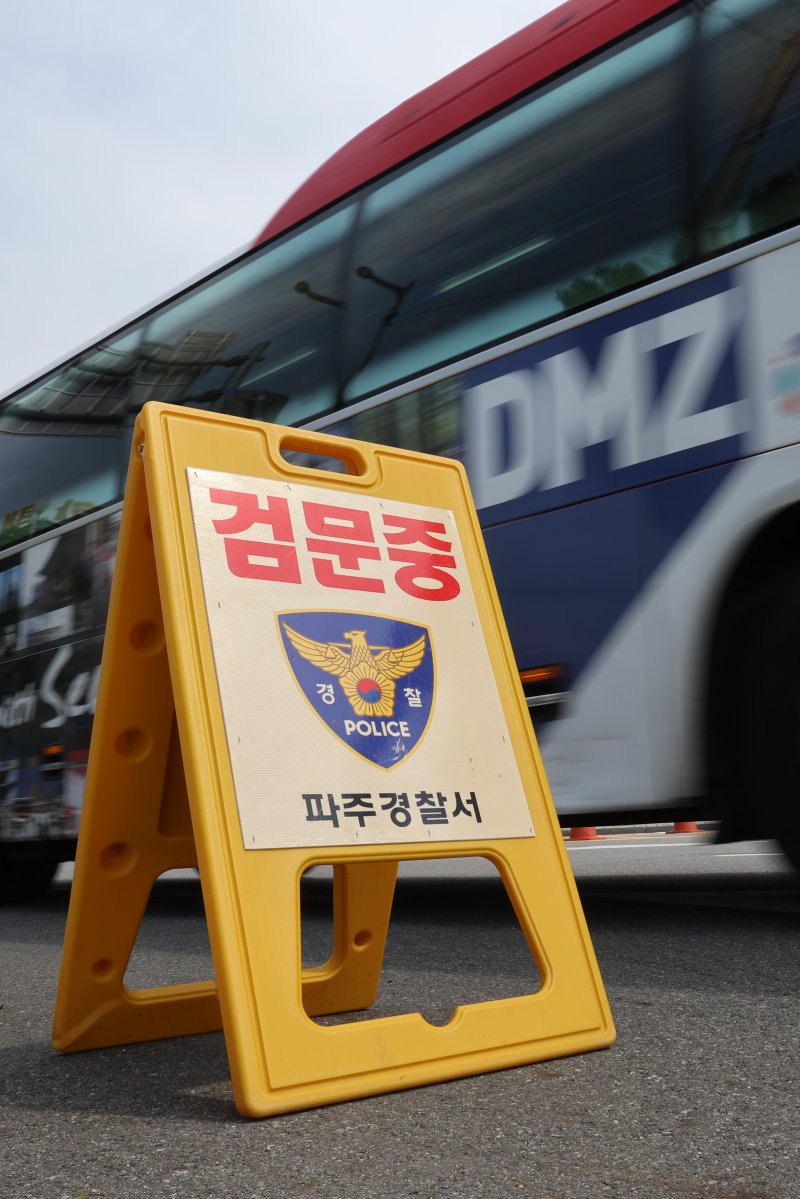 지난 19일 경기도 파주시 임진각에서 경찰의 검문 푯말 뒤로 안보관광 버스가 이동하고 있다. 앞서 납북자가족모임은 지난 14일부터 다음 달 10일까지 임진각에서 대북 전단을 살포하겠다며 집회 신고를 마쳤다. 연합뉴스