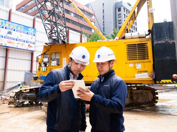 <span id='_stock_code_023410' data-stockcode='023410'>유진기업</span> 직원들이 건설현장에서 콘라이브를 통해 레미콘 출하정보를 확인하고 있다. 유진기업 제공