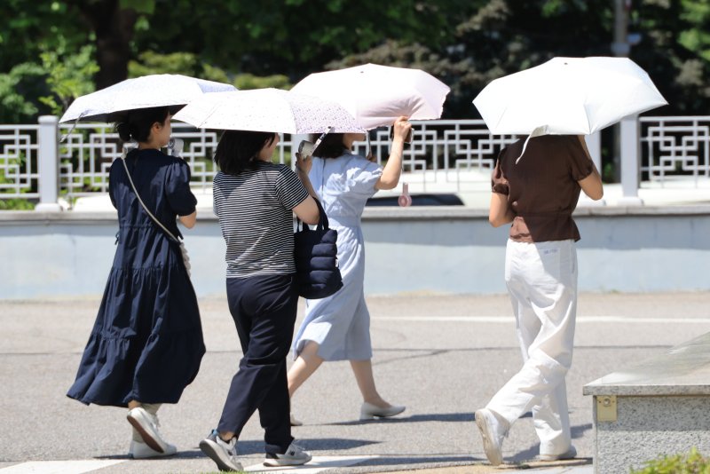 폭염이 이어진 지난 10일 서울 서초구에서 시민들이 내리쬐는 땡볕에 양산을 쓰고 걸어가고 있다. /사진=연합뉴스