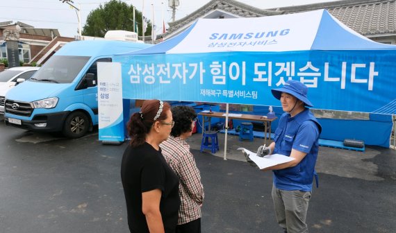 지난 18일 충청남도 예산군 삽교읍에서 <span id='_stock_code_005930' data-stockcode='005930'>삼성전자</span>서비스 엔지니어가 수해 복구 특별 점검 서비스를 실시하고 있다. 삼성전자 제공