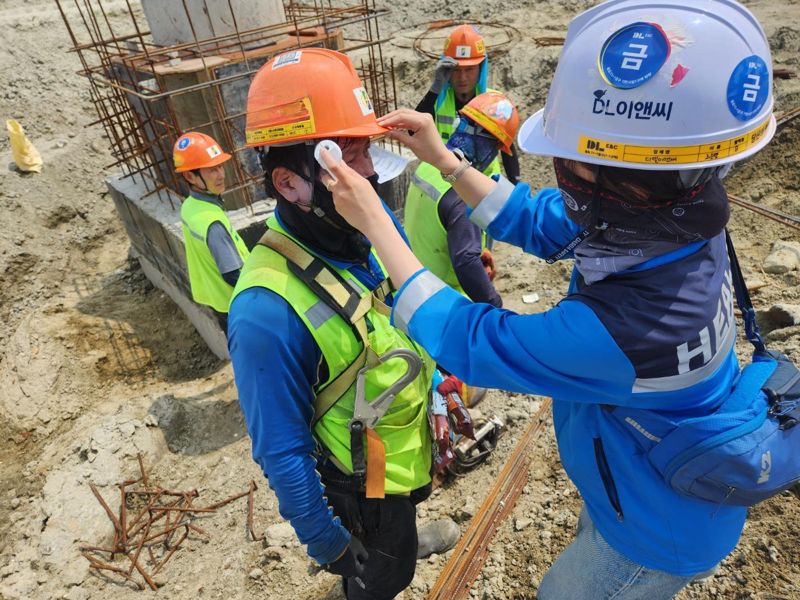 <span id='_stock_code_375500' data-stockcode='375500'>DL이앤씨</span> 현장 안전보건관리자가 근로자의 체온을 측정하고 건강상태를 확인하고 있다. DL이앤씨 제공