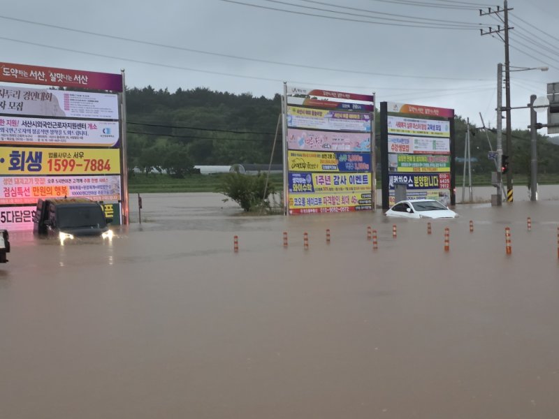 지난 17일 오전 충남 서산시 성연면 이안큐브 앞 도로가 호우로 침수돼 차량들이 물에 잠겨 있다. 뉴시스