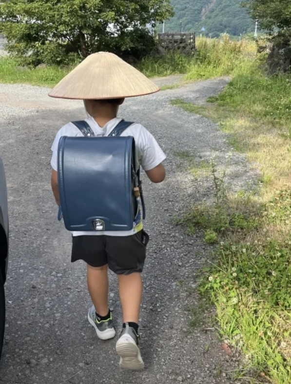 최근 X엔 일본의 한 엄마가 삿갓형 양산을 쓰고 등교하는 초등학생 아들의 뒷모습을 찍은 사진을 올린 뒤 뜨거운 반응을 받았다. 사진=X 캡처