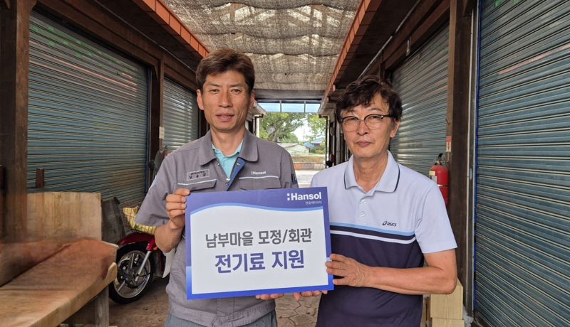 남윤갑 한솔페이퍼텍 인사관리(HR) 지원팀 팀장(왼쪽)과 이재천 남부마을 이장이 전기료 지원 기념촬영을 하고 있다. 한솔홀딩스 제공