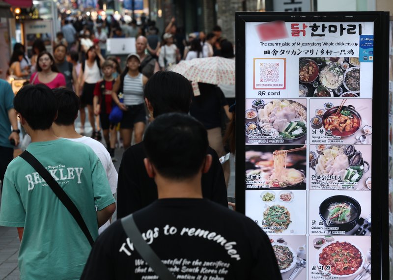 지난달 24일 서울 시내 한 음식점 앞으로 시민들이 지나가고 있다. 연합뉴스