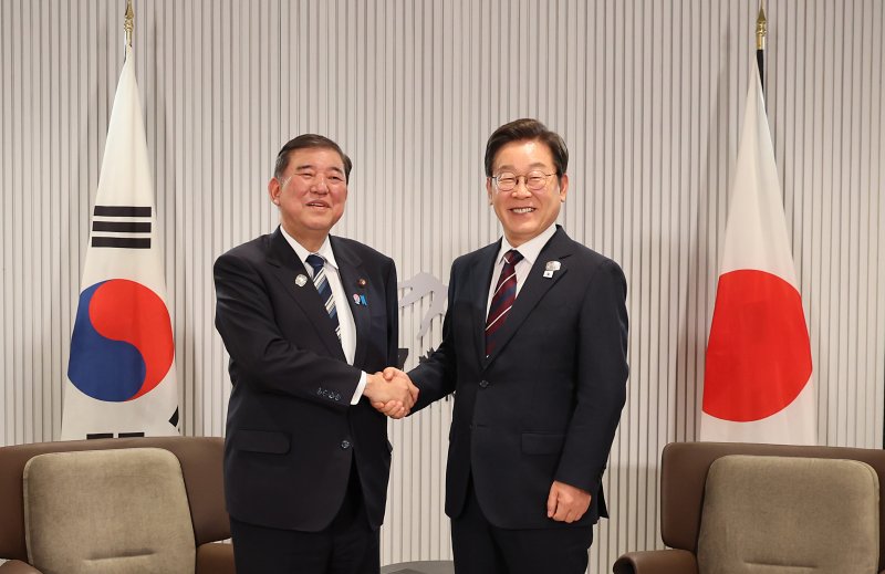 이재명 대통령이 지난 6월 17일(현지시간) 캐나다 앨버타주 캐내내스키스 주요 7개국(G7) 정상회의장에서 열린 한일 정상회담에서 이시바 시게루 일본 총리와 악수하며 기념촬영을 하고 있다. 연합뉴스