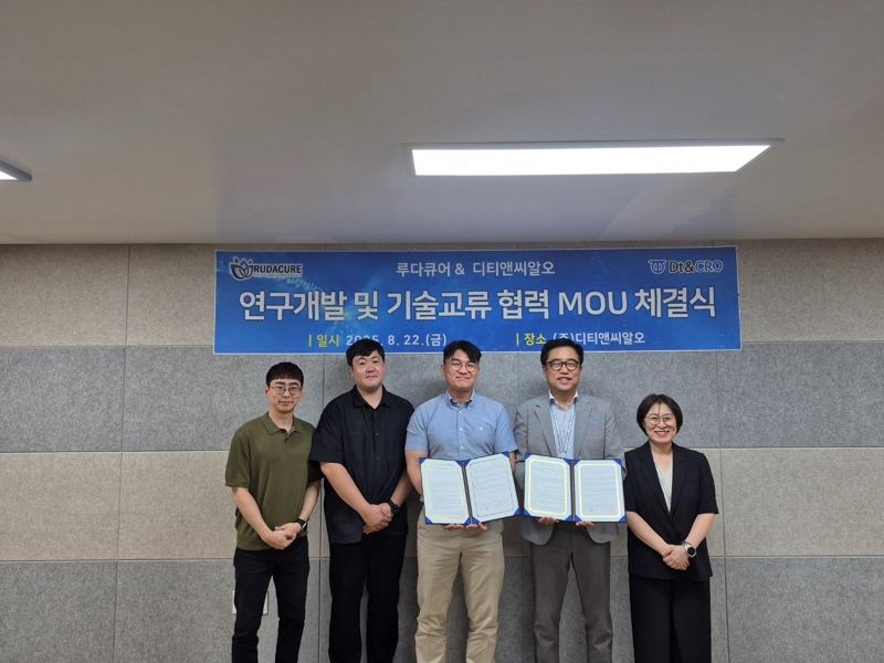 <span id='_stock_code_383930' data-stockcode='383930'>디티앤씨알오</span>와 루다큐어 관계자들이 지난 22일 협약을 체결한 뒤 기념 촬영하고 있다. 왼쪽부터 루타큐어 전하원 연구기획팀장, 루다큐어 김윤연 중앙연구소 효능연구팀장, 루다큐어 김승훈 부사장, 디티앤씨알오 이철규 부사장, 디티앤씨알오 박지은 컨설팅센터장. 디티앤씨알오 제공