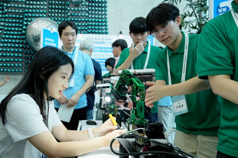 <span id='_stock_code_022100' data-stockcode='022100'>포스코DX</span> 전국 청소년 AI 창의 경진대회에서 지능형 조명 로봇팔 시스템을 개발한 참가자가 시연을 보이고 있다. 포스코DX 제공