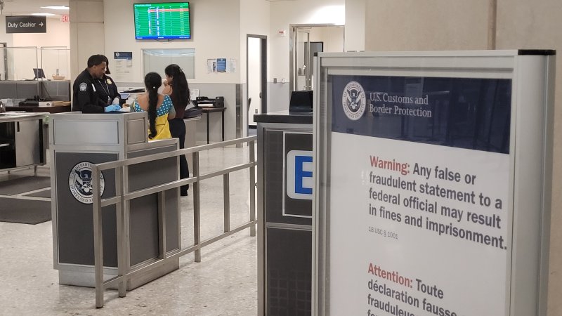 25일(현지시간) 미국 워싱턴DC 인근 덜레스 국제공항에 도착한 승객들이 입국 심사대에서 가방 검색을 받고 있다. 안내판에는 거짓 증언을 할 경우 벌금이나 구금에 처할 수 있다는 경고가 적혀 있다. 2025.6.26 &#x2F;사진&#x3D;연합뉴스