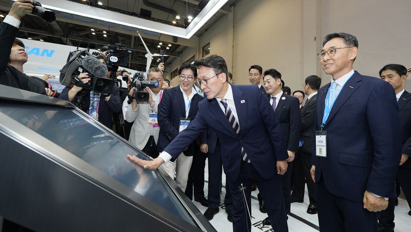 27일 ‘기후산업국제박람회’ 두산 부스에서 김민석 국무총리(가운데)가 <span id='_stock_code_034020' data-stockcode='034020'>두산에너빌리티</span> 정연인 부회장(오른쪽)의 안내를 받으며 전시 패널을 살펴보고 있다. 두산 제공