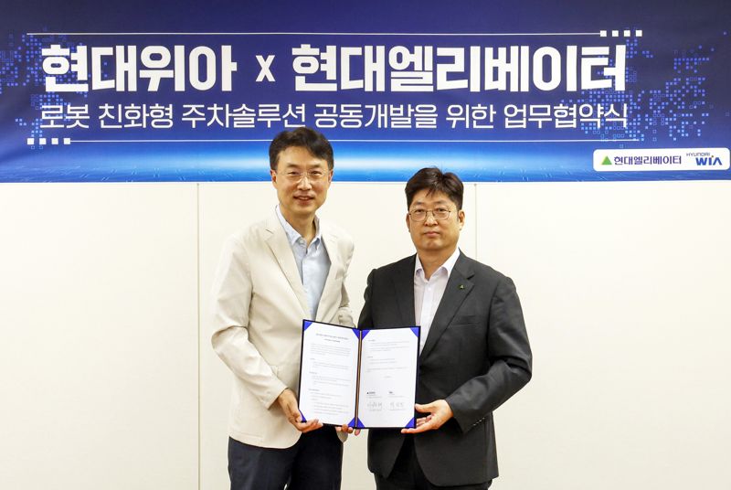 이원해 <span id='_stock_code_017800' data-stockcode='017800'>현대엘리베이</span>터 승강기사업본부장(오른쪽)과 백익진 <span id='_stock_code_011210' data-stockcode='011210'>현대위아</span> 모빌리티솔루션사업부장이 28일 오후 경기도 현대위아 의왕연구소에서 업무협약(MOU)을 체결한 뒤 포즈를 취하고 있다. 현대엘리베이터 제공