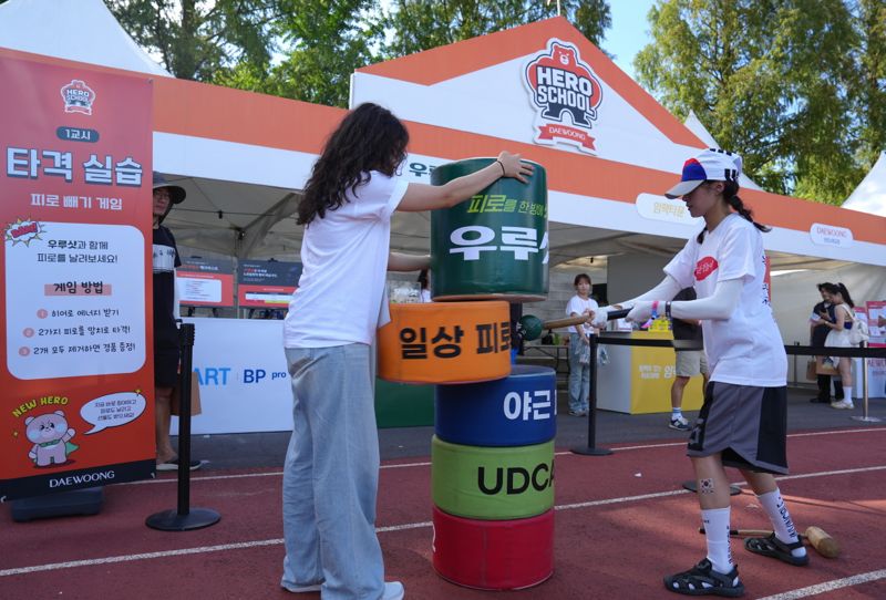 지난 15일부터 17일까지 전북대학교 대운동장에서 열린 '2030 생활 속 조기 발견' 캠페인에서 한 참가자가 게임용 망치로 피로를 날려버리는 체험 이벤트에 참여하고 있다. <span id='_stock_code_069620' data-stockcode='069620'>대웅제약</span> 제공