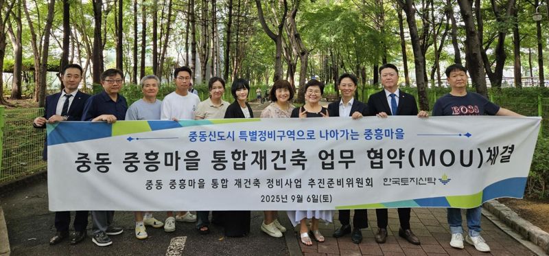 중흥마을 정비사업 추진준비위원회와 <span id='_stock_code_034830' data-stockcode='034830'>한국토지신탁</span> 관계자들이 지난 6일 업무협약 체결식에서 기념촬영을 하고 있다. 한국토지신탁 제공