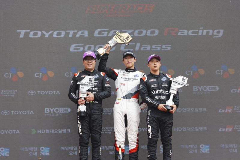 강원도 인제 스피디움에서 지난 7일 열린 ‘2025 오네 슈퍼레이스 챔피언십’ 6라운드에서 <span id='_stock_code_073240' data-stockcode='073240'>금호타이어</span>가 후원하는 ‘금호 SL 모터스포츠팀’ 노동기 선수(가운데)가 1위를 차지하고 트로피를 들어 올리고 있다. 금호타이어 제공