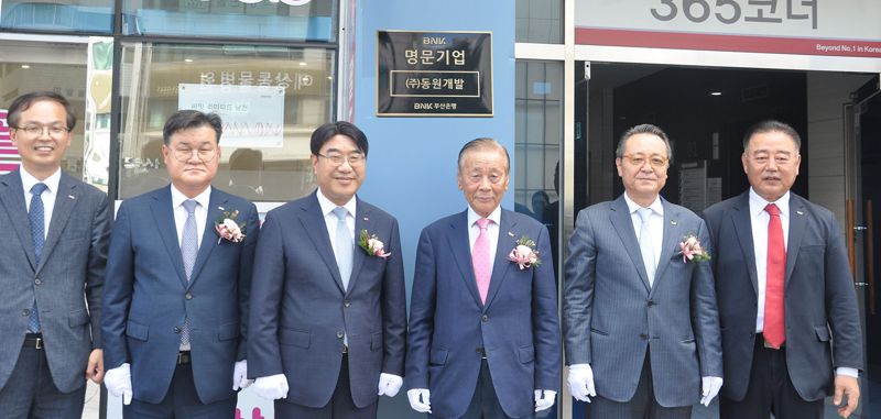 부산 수영구 민락동 동원개발 사옥에서 가진 &#39;BNK부산은행 명문기업&#39; 현판식에 장복만 동원개발 회장(왼쪽 네번째)과 방성빈 BNK부산은행장(왼쪽 세번째) 등이 기념촬영을 하고 있다. 동원개발 제공