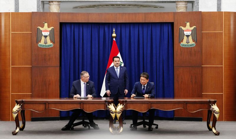 14일(현지시간) 이라크 총리실에서 열린 계약 서명식에서 토탈에너지스 패트릭 푸얀 CEO(왼쪽)와 <span id='_stock_code_000720' data-stockcode='000720'>현대건설</span> 류성안 플랜트사업본부장(오른쪽)이 모하메드 시아 알수다니 이라크 총리 참관 아래 계약서에 서명하고 있다. 현대건설 제공