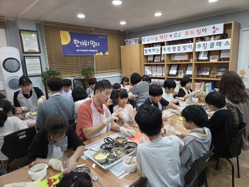 지난 24일 서울 성동구 금호동 꿈터지역아동센터에서 CJ푸드빌 임직원 봉사자들과 아이들이 추석 명절 음식을 만들고 있다. CJ그룹 제공