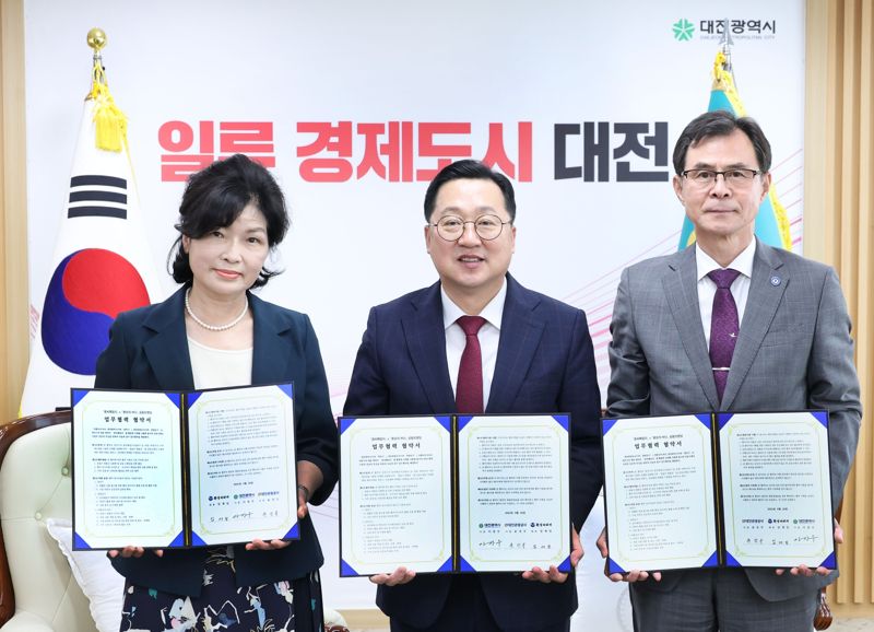 이장우 대전시장(가운데)이 29일 대전시청에서 임재일 환상의 바다 대표(맨 왼쪽), 윤성국 대전관광공사 사장과 ‘꿈돌이 명품김’ 출시를 위한 업무협약을 맺은 뒤 협약서를 들업보이고 있다.