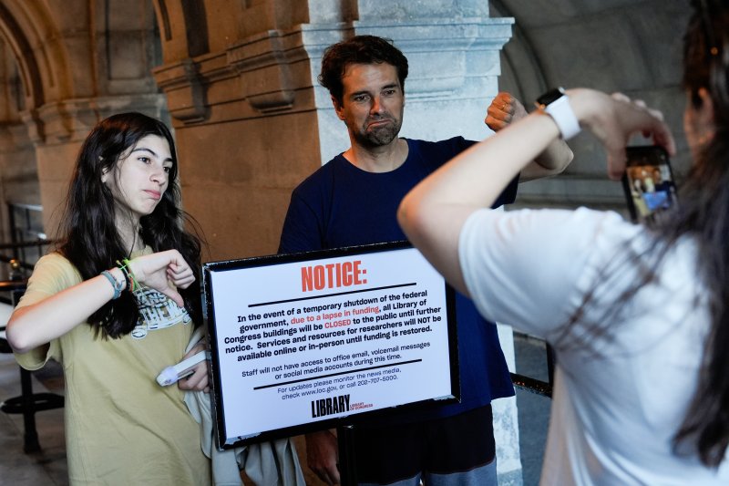 1일(현지시간) 미국 워싱턴DC의 국회도서관이 미국 연방정부 일시 업무 정지(셧다운) 여파로 문을 닫은 가운데 시민들이 휴관 공지문을 배경으로 사진을 찍고 있다.AP연합뉴스