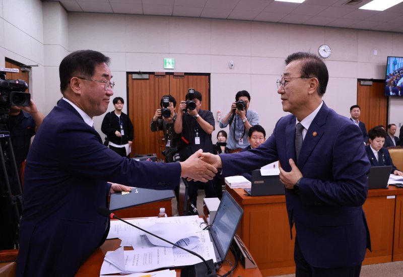 13일 서울 여의도 국회에서 열린 국토교통부 등에 대한 국토교통위원회 국정감사에서 김윤덕 국토교통부 장관이 선서문을 맹성규 국토교통위원장에게 전달한 뒤 악수하고 있다. 연합뉴스