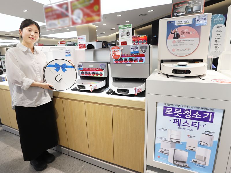 롯데하이마트 모델이 '로봇청소기 페스타' 행사대상 제품을 들고 포즈를 취하고 있다. 롯데하이마트 제공