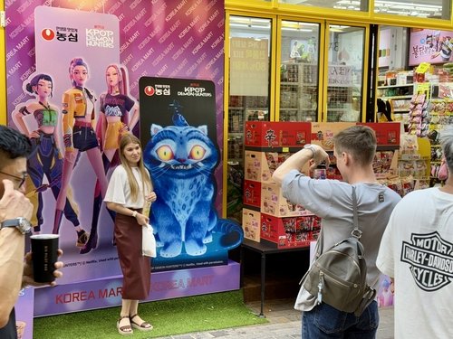 한 외국인 관광객이 농심과 케이팝 데몬 헌터스 협업 홍보물 앞에서 포즈를 취하고 있다. 사진=연합뉴스