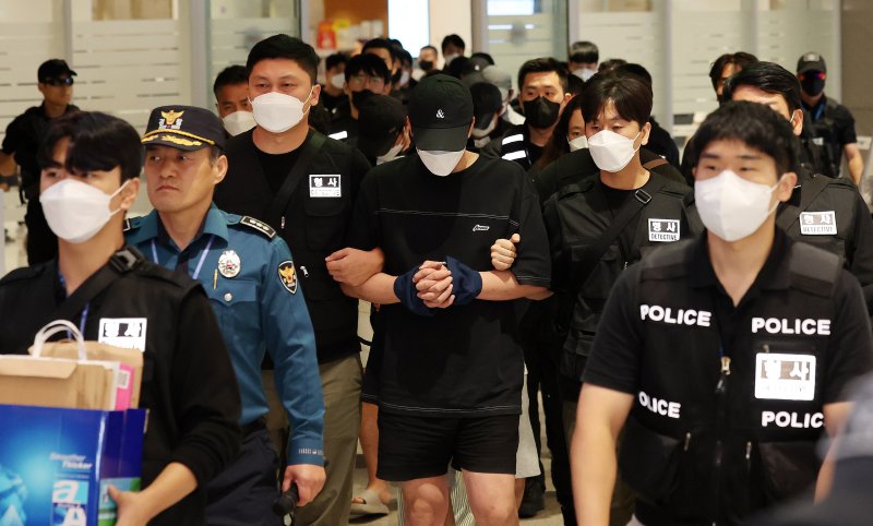 캄보디아 당국의 범죄단지 단속으로 적발돼 구금됐던 한국인들이 18일 오전 인천국제공항 2터미널을 통해 송환되고 있다. 이번 송환 대상자들은 이른바 '웬치'로 불리는 캄보디아 범죄단지에서 보이스피싱이나 로맨스 스캠(사기) 등 범죄에 가담한 혐의를 받고 있다. 이들은 호송 차량 23대 등을 타고 충남경찰청 등 6개 관할 경찰관서로 압송된다. 뉴스1화상