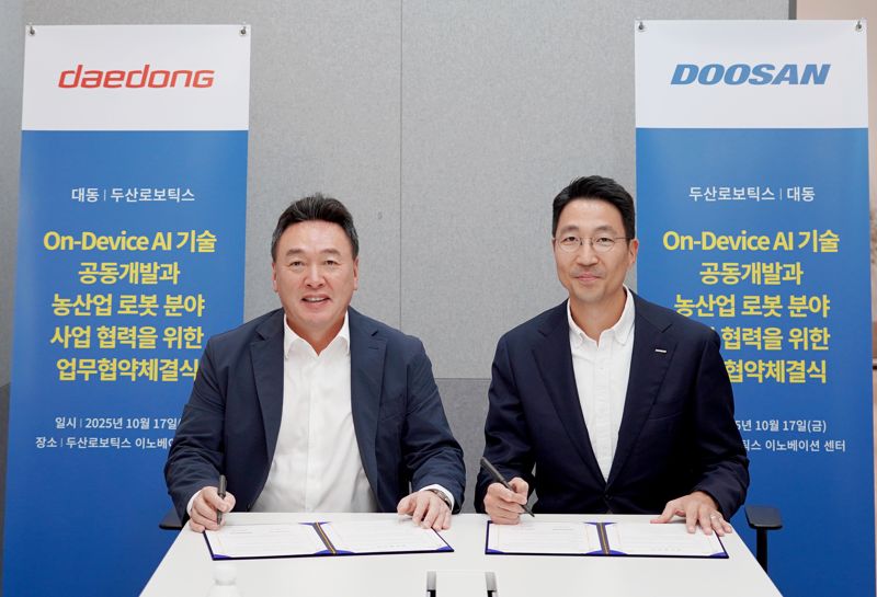지난 17일 경기도 성남시 분당구에 위치한 <span id='_stock_code_454910' data-stockcode='454910'>두산로보틱스</span> 이노베이션 센터에서 열린 온디바이스 인공지능(AI) 기술 공동개발과 농산업 로봇 분야 사업 협력을 위한 업무협약 체결식에서 원유현 <span id='_stock_code_000490' data-stockcode='000490'>대동</span> 대표이사(왼쪽)와 김민표 두산로보틱스 대표가 협약서에 서명을 하고 있다. 대동그룹 제공