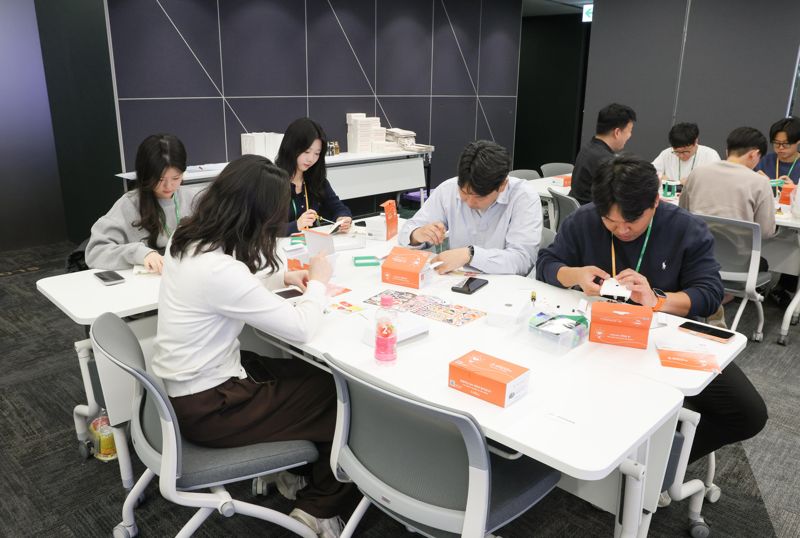 태양광 랜턴 만들기 봉사활동에 참여한 <span id='_stock_code_017800' data-stockcode='017800'>현대엘리베이</span>터 임직원들이 점심시간을 이용해 제품을 조립하고 있다. 현대엘리베이터 제공