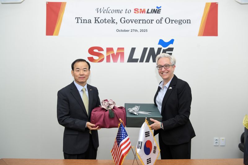 SM상선 강호준 대표이사(왼쪽)가 지난 27일 서울 서대문구 SM그룹 신촌사옥에서 미국 오리건주 티나 <span id='_stock_code_052330' data-stockcode='052330'>코텍</span> 주지사를 영접한 뒤 선물을 교환하며 포즈를 취하고 있다. SM그룹 제공