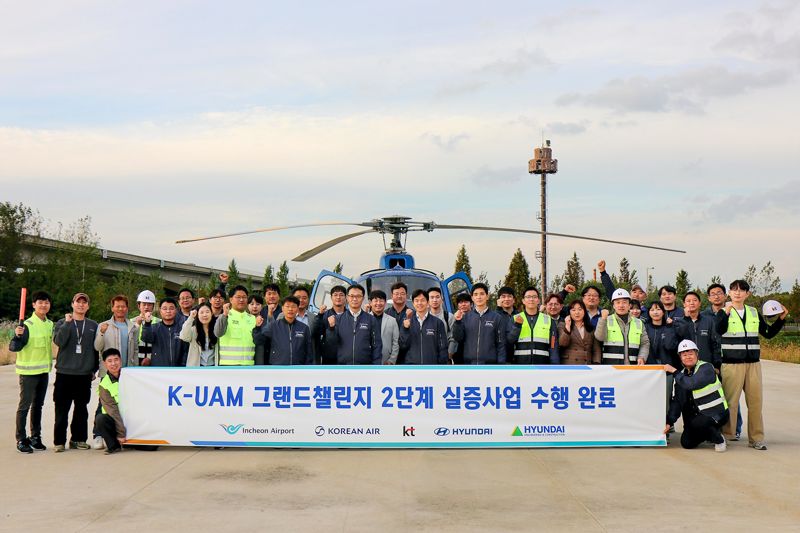 <span id='_stock_code_030200' data-stockcode='030200'>KT</span>를 비롯한 현대자동차, 현대건설, 인천국제공항공사, 대한항공이 함께하는 K-UAM 원팀이 인천 아라뱃길 실증 현장에서 기념사진을 촬영하는 모습. KT 제공