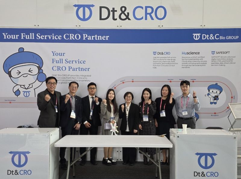 제48차 한국비임상시험연구회 현장에 마련된 <span id='_stock_code_383930' data-stockcode='383930'>디티앤씨알오</span> 부스에서 임직원들이 기념 촬영을 하고 있다. 디티앤씨알오 제공