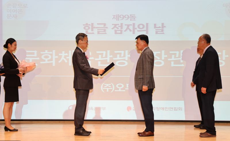 지난 4일 '제99돌 한글 점자의 날 기념식'에서 황성만 <span id='_stock_code_007310' data-stockcode='007310'>오뚜기</span> 대표이사(오른쪽 두번째)가 김영수 문화체육관광부 제1차관(왼쪽 두번째)에게 표창장을 받고 있다. 오뚜기 제공 