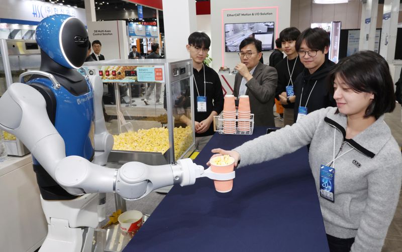 &#39;2025 로보월드&#39;가 5일 경기 고양시 킨텍스 제1전시장 1~2홀에서 열린 가운데 <span id='_stock_code_348340' data-stockcode='348340'>뉴로메카</span> 휴머노이드 로봇이 팝콘을 담아 주고 있다. 사진&#x3D;박범준 기자
